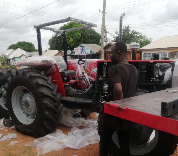 Worker preparing a newly delivered red tractor
