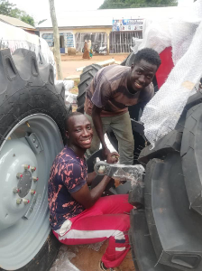 Team members fitting a tractor wheel